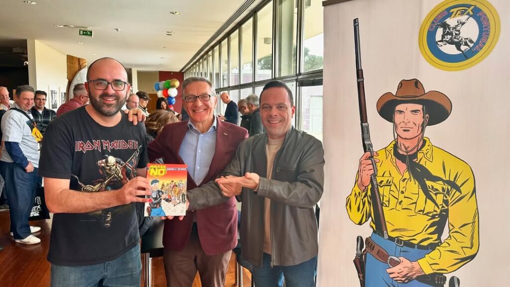 Thiago Gardinali e Leonardo Campos, diretor da editora 85, entregando a Fabio Civitelli uma edição de Mister No com uma história clássica ilustrada por ele - 9ª Mostra do Clube Tex Portugal - 2024